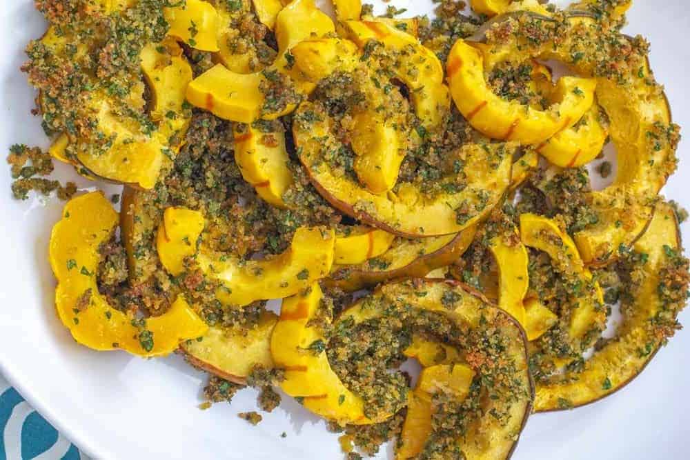 roasted winter squash with garlic herb topping on a platter