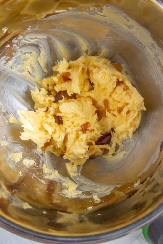 Butter and brown sugar mixture partially blended in a metal mixing bowl.