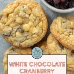 White chocolate cranberry cookies with a small bowl of dried cranberries on the side.