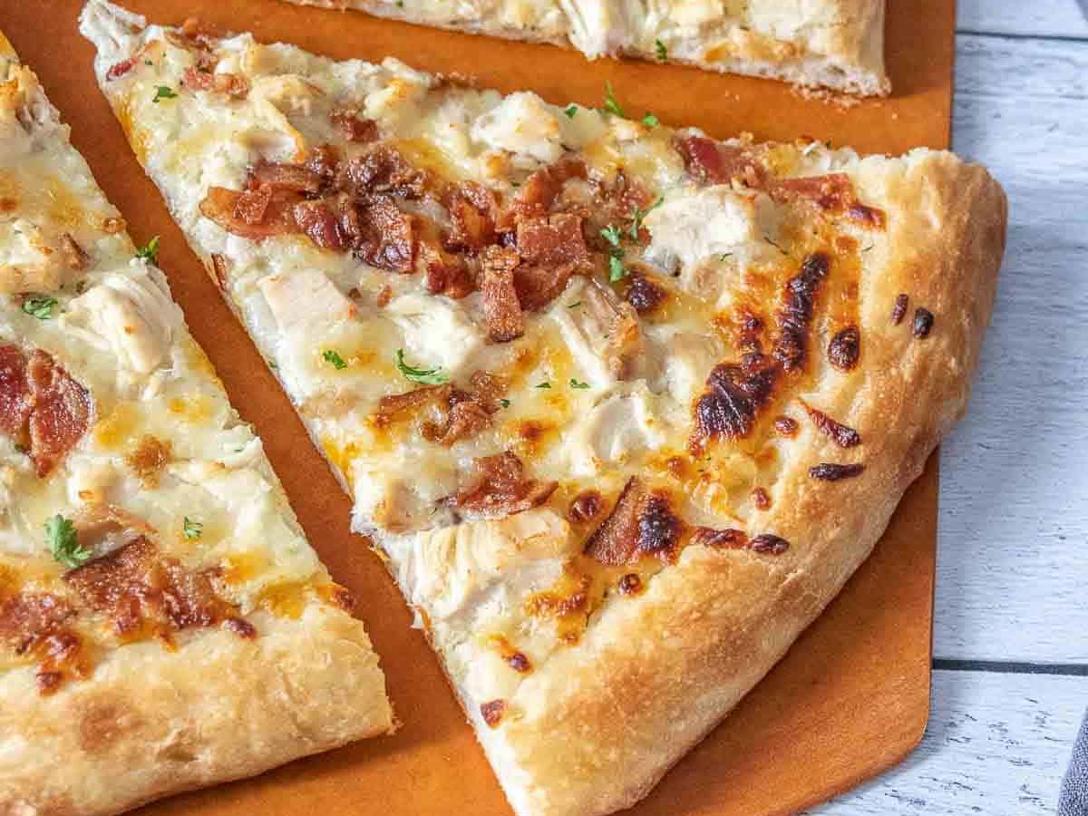 Chicken bacon ranch pizza with a slice being pulled away.