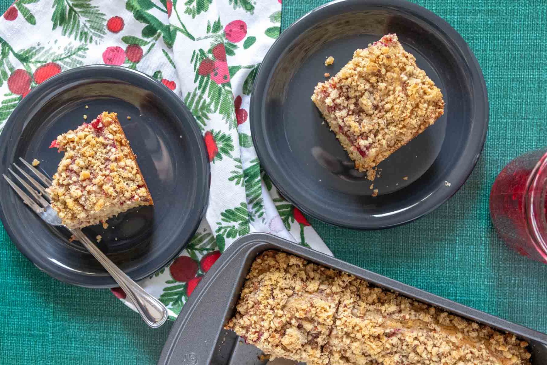 Overhead of cranberry coffee cake served onto black plates.