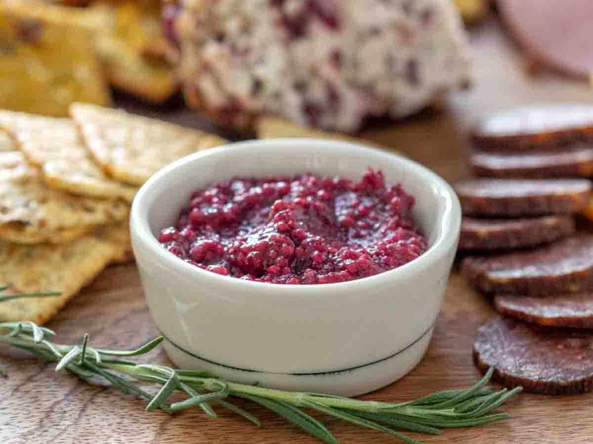 cranberry mustard in white bowl on cheese board