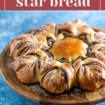 A star-shaped bread with Nutella filling on a wooden platter, sprinkled with powdered sugar.