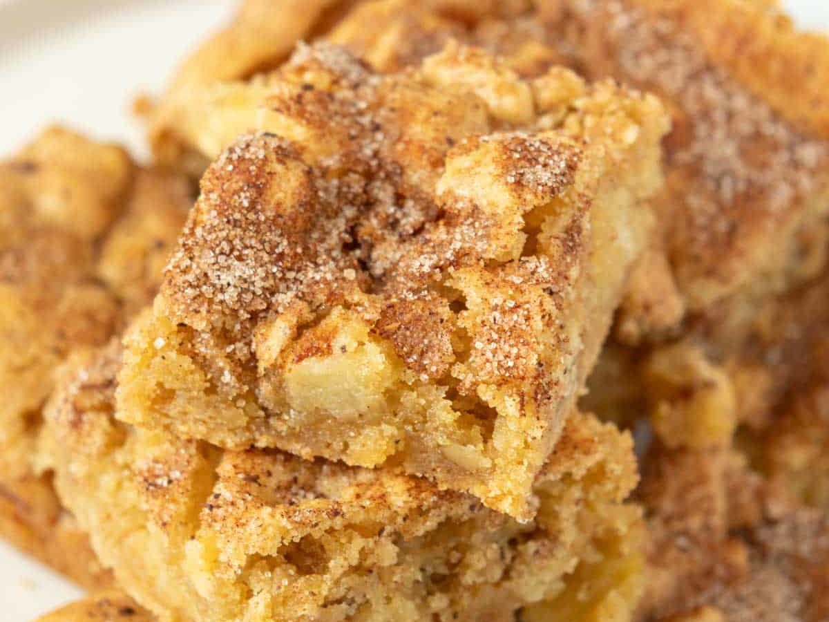 A stack of cinnamon apple squares on a white plate.