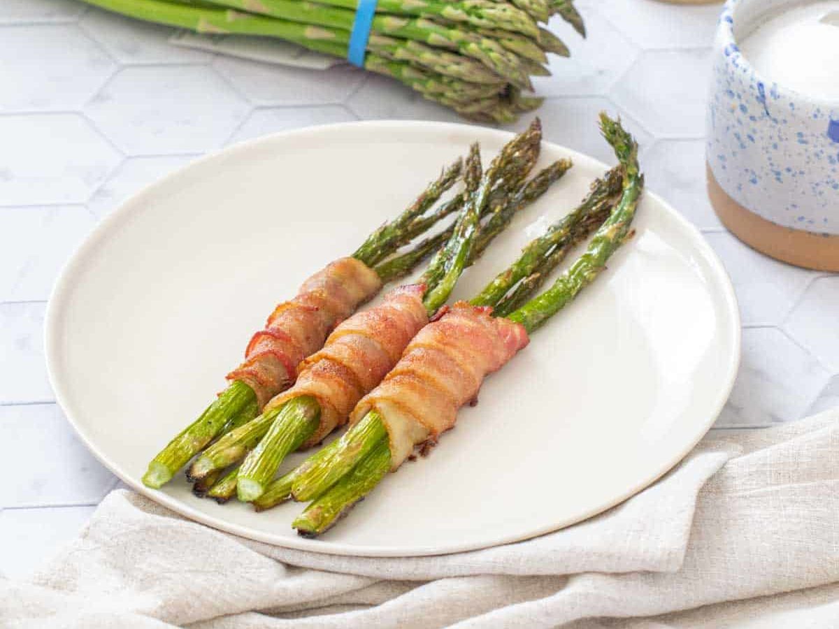 bacon wrapped asparagus with asparagus bundle behind