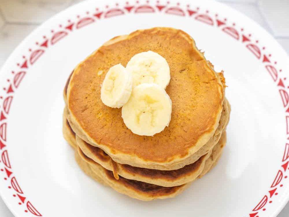 overhead of banana bread pancakes with banana slices on top