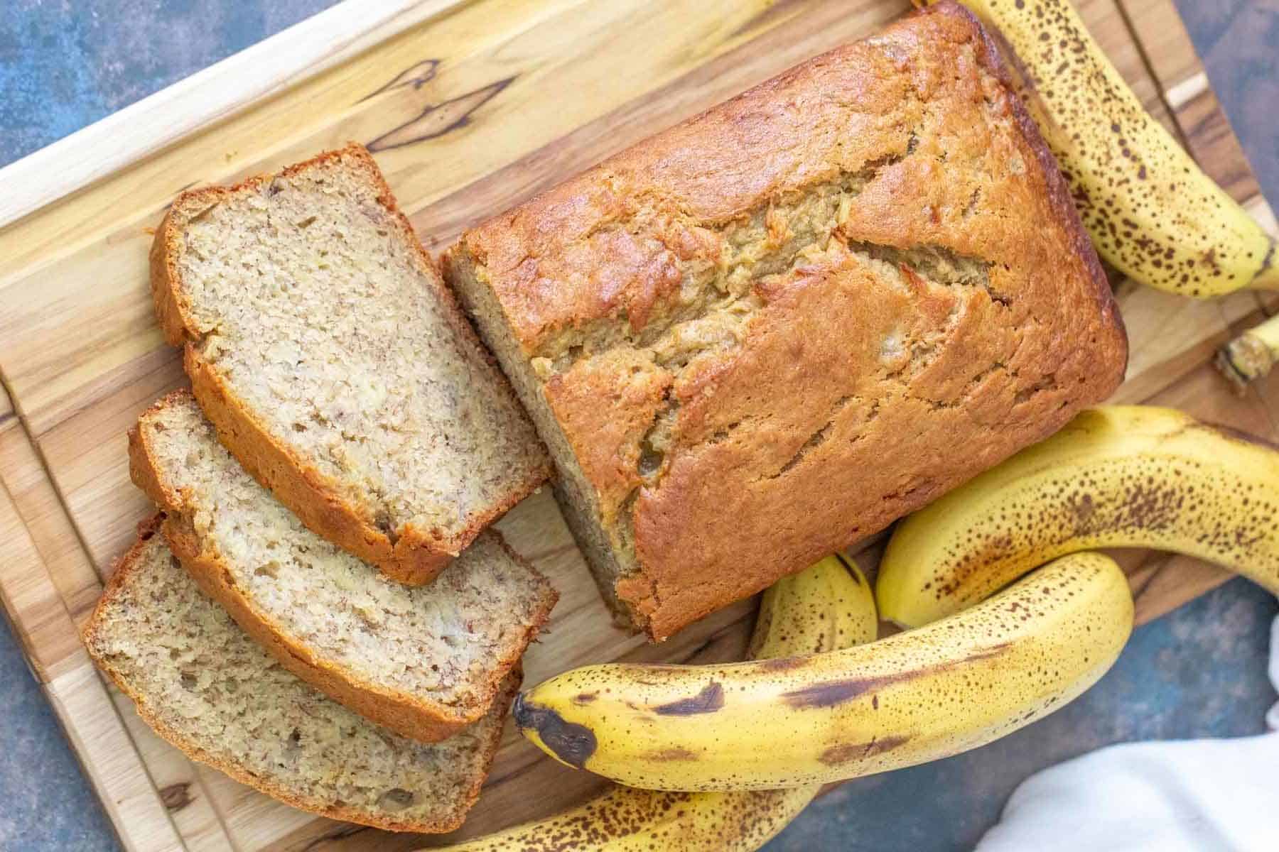 Loaf of banana bread with slices cut on a cutting board.