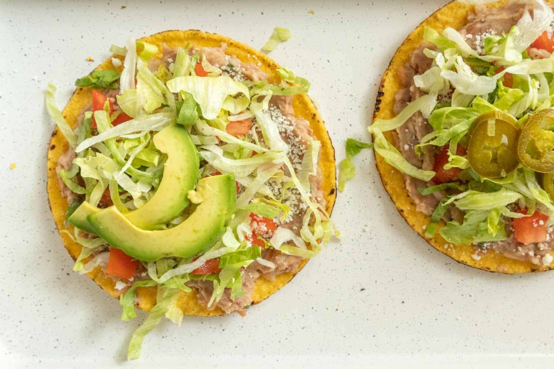 Two tostadas on a white plate.