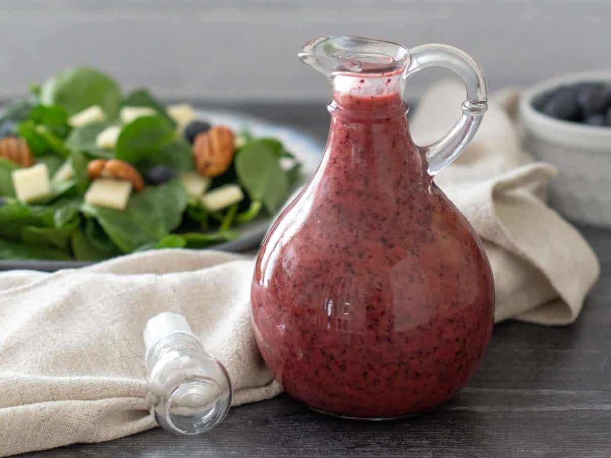 bottle of blueberry vinaigrette with salad behind