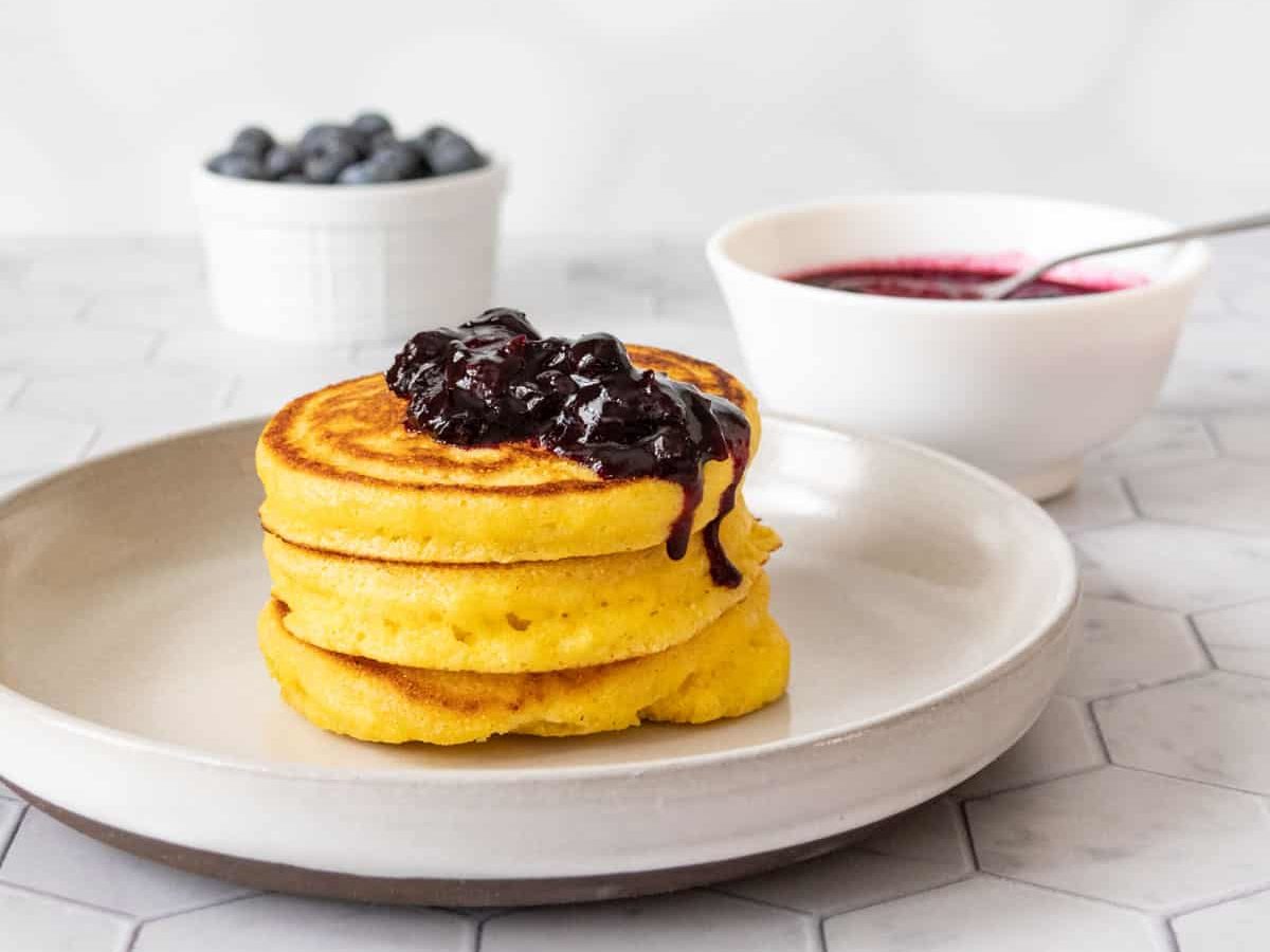 Cornmeal pancakes with blueberry sauce on top.