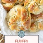 Close-up of a basket of fluffy garlic rolls topped with herbs and parmesan. The text reads, "Fluffy Garlic Rolls. Get the recipe at stetted.com.