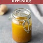 A glass jar with orange ginger salad dressing, sealed with a clasp. Text above reads "ginger salad dressing.