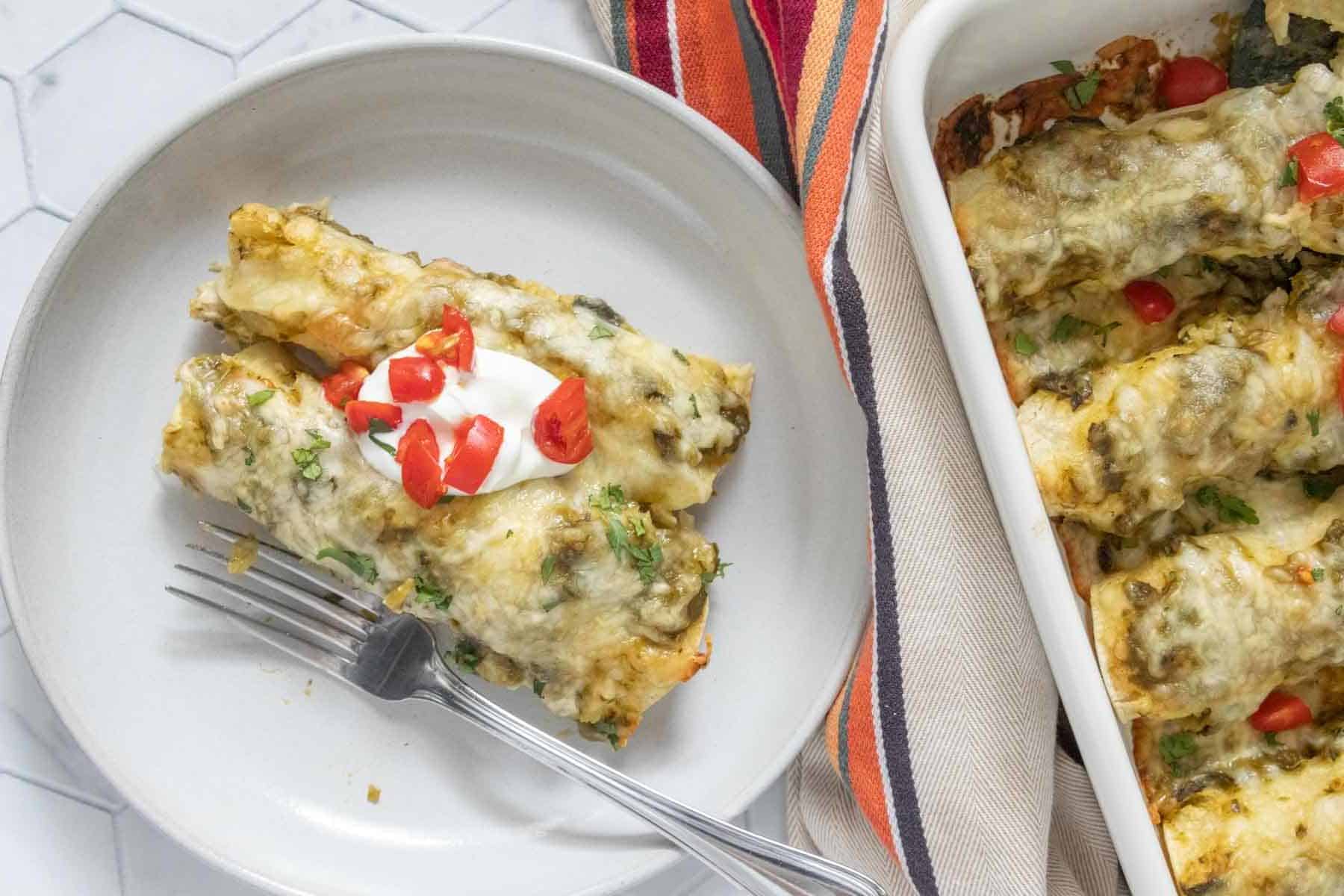 Mexican enchiladas on a plate with a fork.