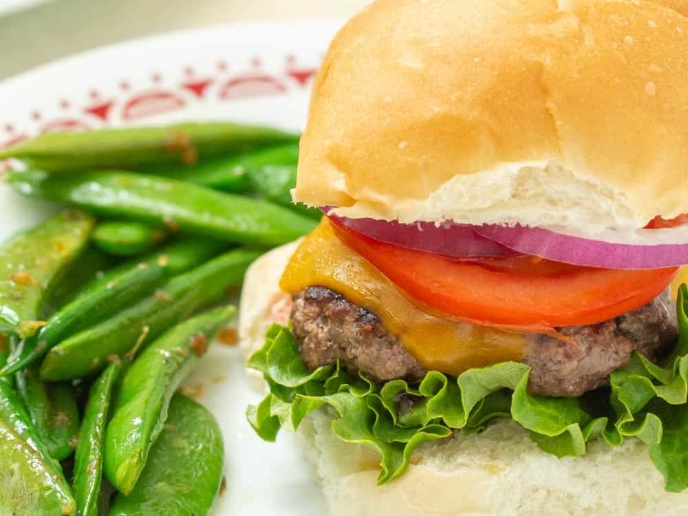 ground bison burger served with snap peas