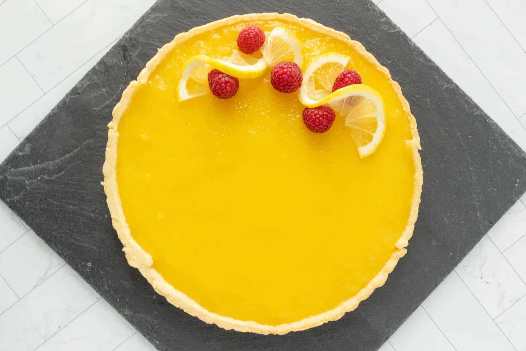 A lemon tart with raspberries on top.