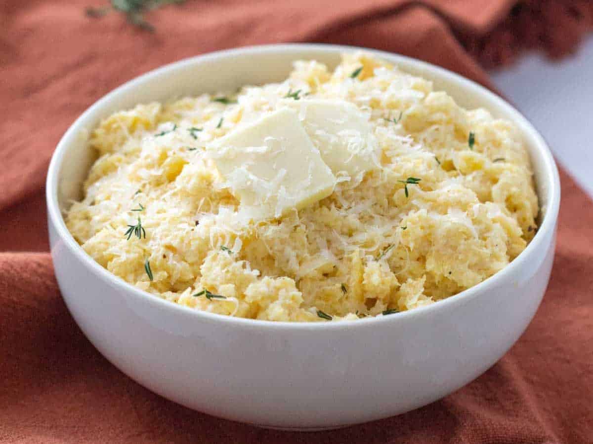 mashed rutabaga in a bowl with butter and cheese