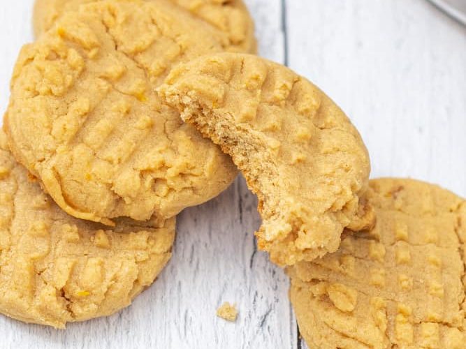 stack of peanut butter cookies with a bite out of top cookie