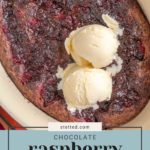 Oval baking dish with chocolate raspberry pudding cake topped with two scoops of vanilla ice cream.