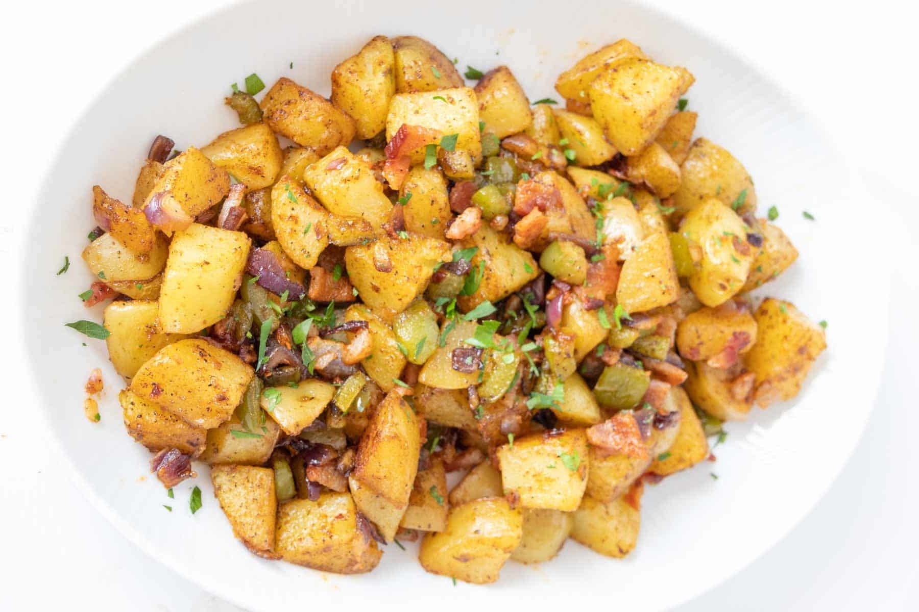 Roasted breakfast potatoes on a white serving plate.