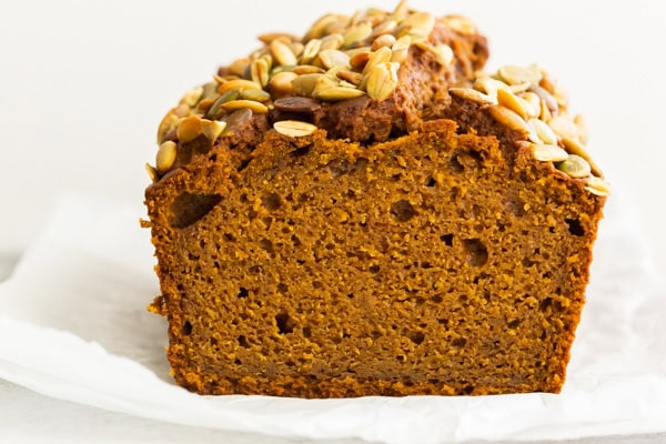 A loaf of pumpkin bread sliced in half to show the inside.