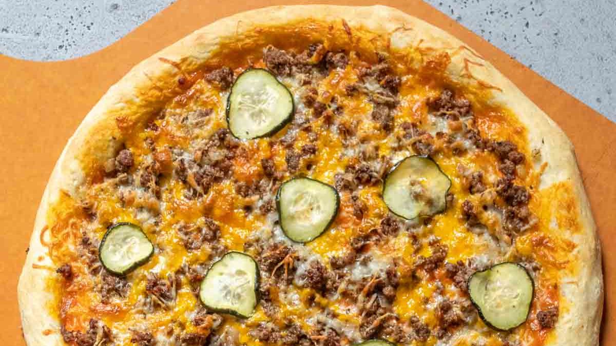 Baked cheeseburger pizza on a pizza peel.