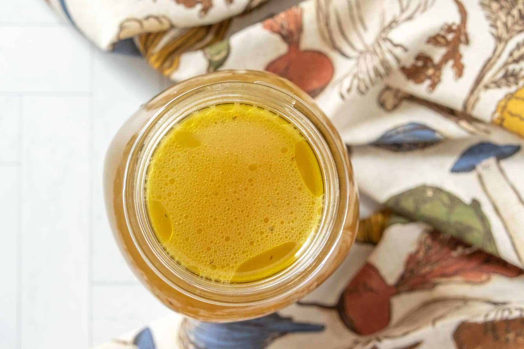 A jar of chicken broth is sitting on a table.