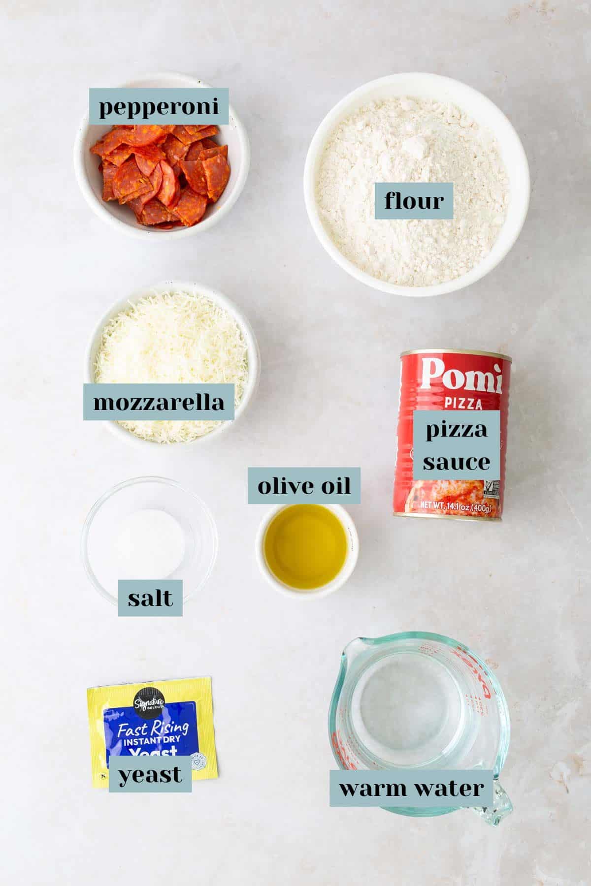 Ingredients for pizza dough and toppings: flour, pepperoni, mozzarella, pizza sauce, salt, olive oil, yeast, and warm water.