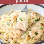 A bowl of creamy shrimp pasta with garnished herbs. A fork is lifting a portion of the pasta. The text above reads "creamy shrimp pasta," and the bottom shows a website link.