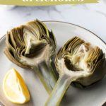 Two halved cooked artichokes and a lemon wedge on a plate. Text reads: "How to cook artichokes, step by step directions.