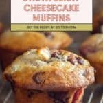 Strawberry cheesecake muffins on a cooling rack with a recipe link banner above.