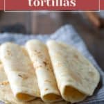 A stack of three homemade flour tortillas rests on a striped cloth, with the text "homemade tortillas" at the top and "stetted.com" at the bottom.